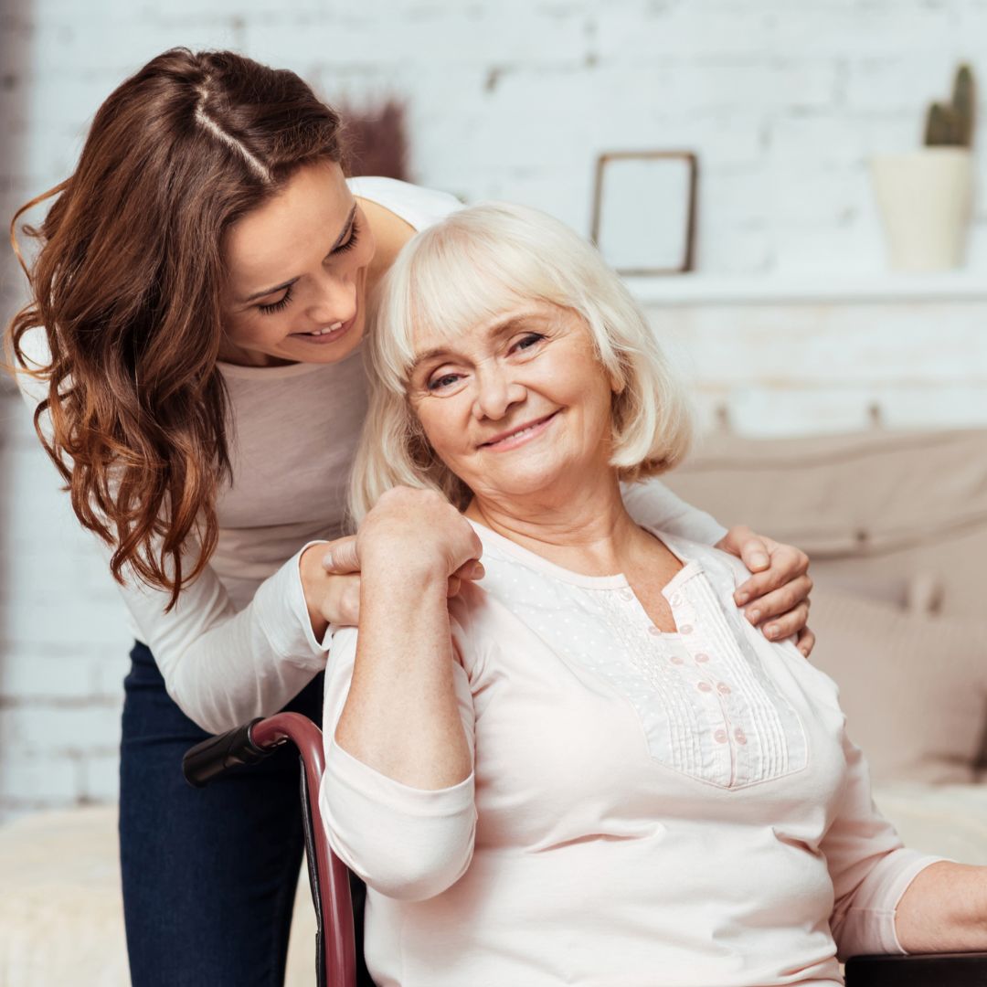 A woman embraces an older woman.